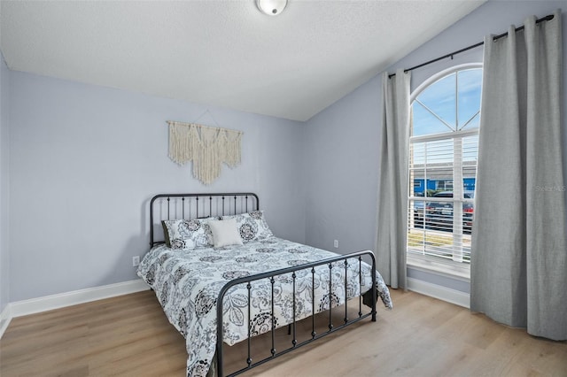 bedroom with lofted ceiling and light hardwood / wood-style flooring