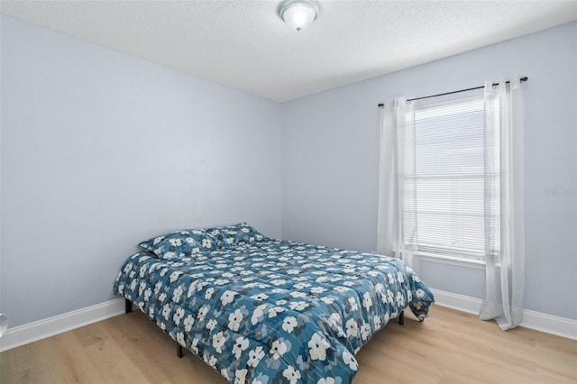 bedroom featuring hardwood / wood-style flooring and a textured ceiling