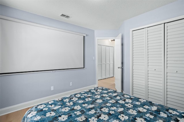 home theater featuring light hardwood / wood-style floors and a textured ceiling