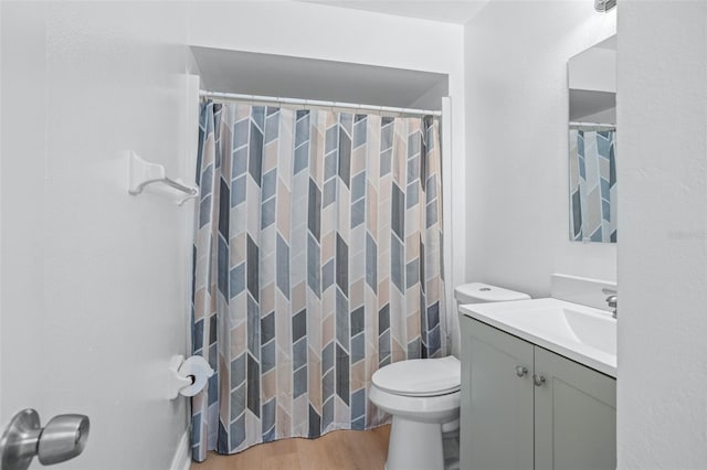 bathroom with wood-type flooring, toilet, vanity, and walk in shower