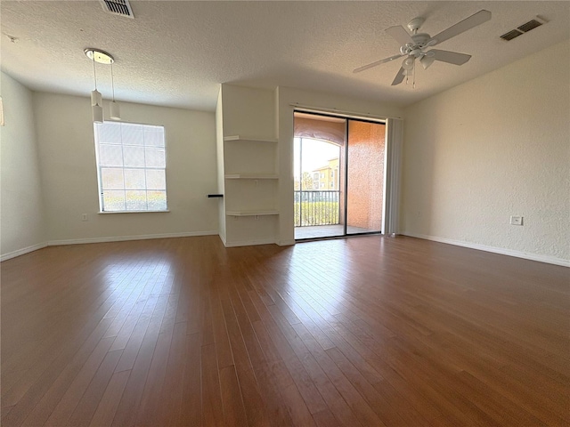 spare room with a textured ceiling, dark hardwood / wood-style floors, and ceiling fan