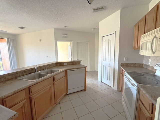 kitchen with sink, white appliances, light tile patterned floors, and a textured ceiling