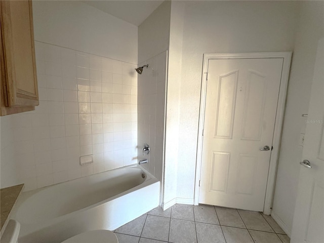 bathroom featuring tile patterned floors, toilet, and tiled shower / bath