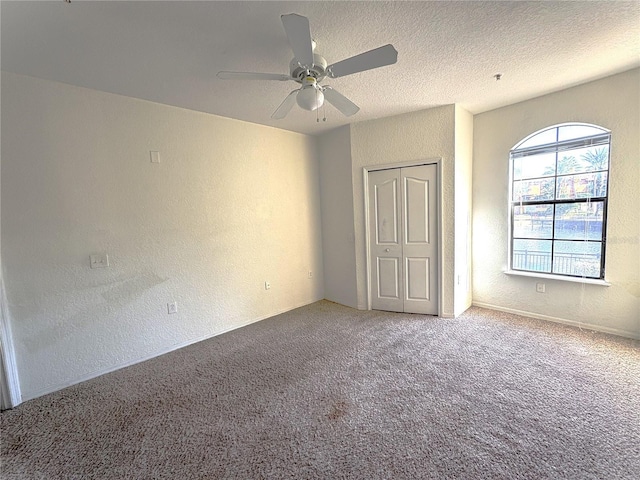 unfurnished bedroom featuring ceiling fan, carpet, a closet, and a textured ceiling