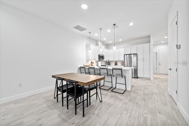 dining space with sink and light hardwood / wood-style floors