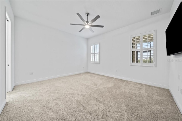 carpeted spare room featuring plenty of natural light and ceiling fan