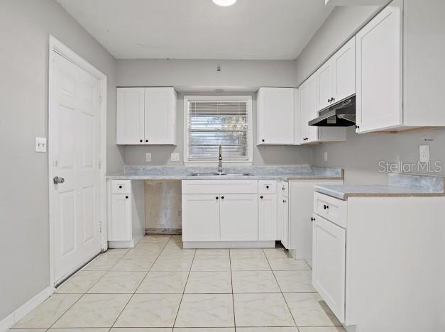 kitchen featuring sink and white cabinetry