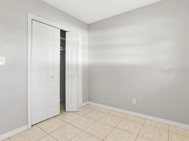 unfurnished bedroom with a closet and light tile patterned floors