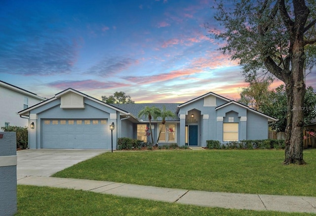 ranch-style home featuring a garage and a yard