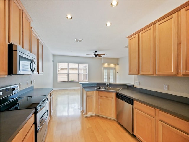 kitchen with kitchen peninsula, ceiling fan, stainless steel appliances, light wood-type flooring, and sink