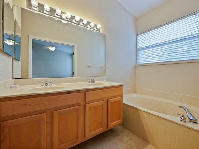 bathroom featuring ceiling fan, a washtub, vanity, and tile patterned flooring