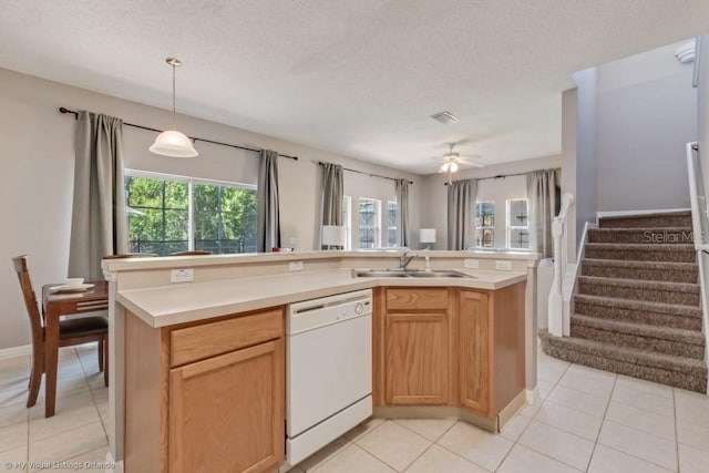 kitchen with sink, light tile patterned floors, dishwasher, a kitchen island with sink, and hanging light fixtures