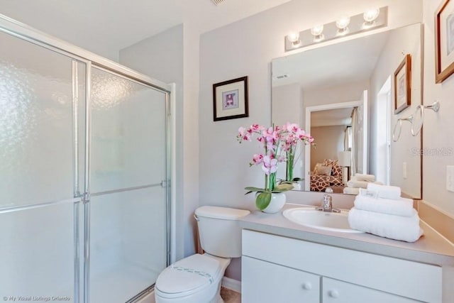 bathroom with vanity, toilet, and a shower with shower door