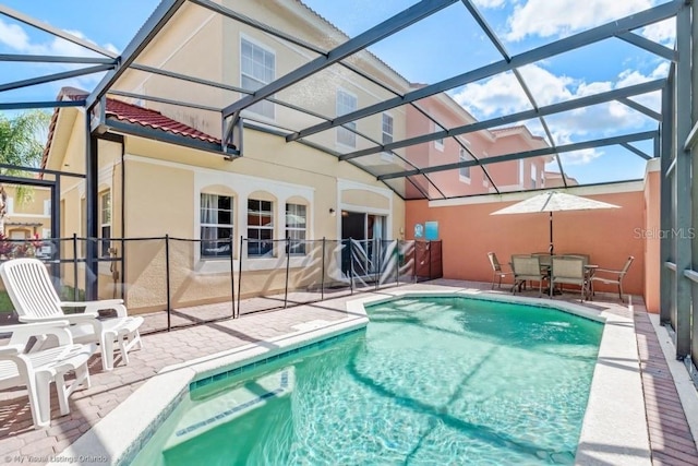 view of pool with a patio and glass enclosure