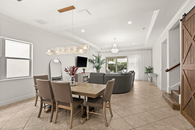 dining area featuring a tray ceiling, ornamental molding, a barn door, and light tile patterned flooring