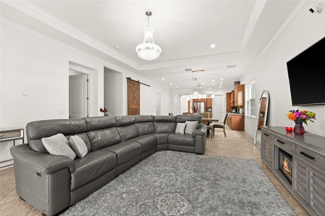 living room featuring an inviting chandelier, ornamental molding, a barn door, and light tile patterned flooring