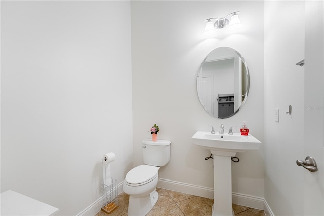 bathroom with toilet, tile patterned flooring, and sink