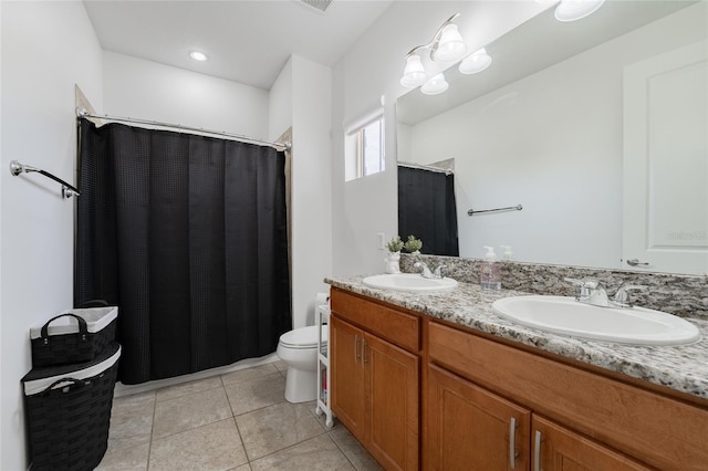 bathroom featuring toilet, vanity, and tile patterned flooring