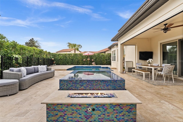 view of pool with ceiling fan, a patio area, and an outdoor living space with a fire pit