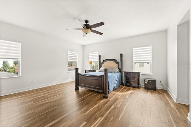 bedroom with a ceiling fan, baseboards, and wood finished floors