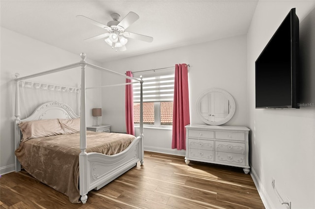 bedroom with ceiling fan, baseboards, and wood finished floors