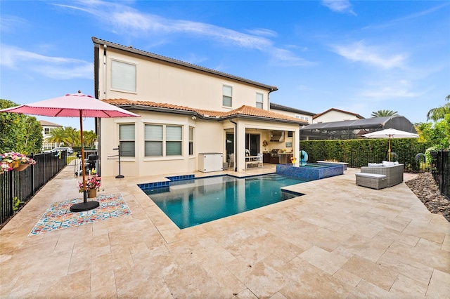 back of house featuring a fenced backyard, a patio, a tiled roof, and an in ground hot tub