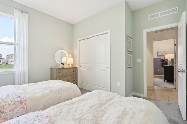 bedroom with a closet and light tile patterned floors