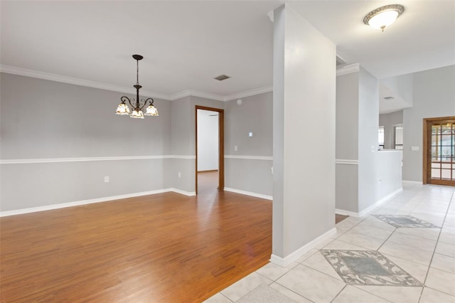 unfurnished room with light tile patterned flooring, ornamental molding, and an inviting chandelier