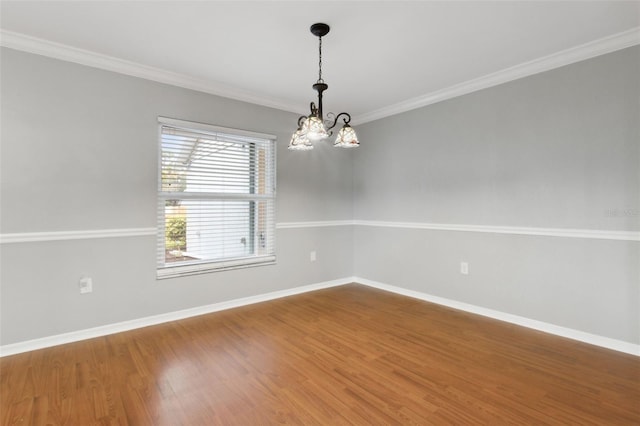 empty room with ornamental molding, hardwood / wood-style floors, and an inviting chandelier