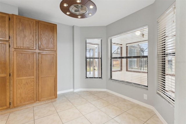 unfurnished dining area with light tile patterned flooring