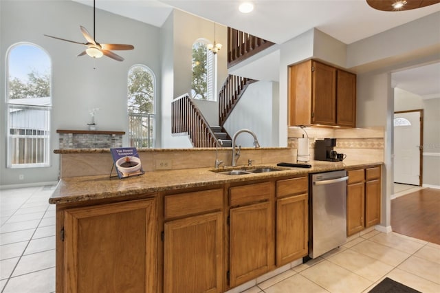 kitchen featuring sink, kitchen peninsula, dishwasher, and light tile patterned flooring