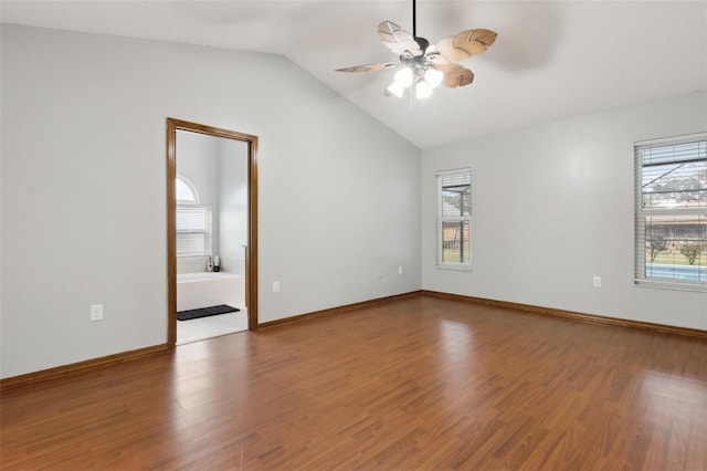 spare room with a wealth of natural light, wood-type flooring, and vaulted ceiling