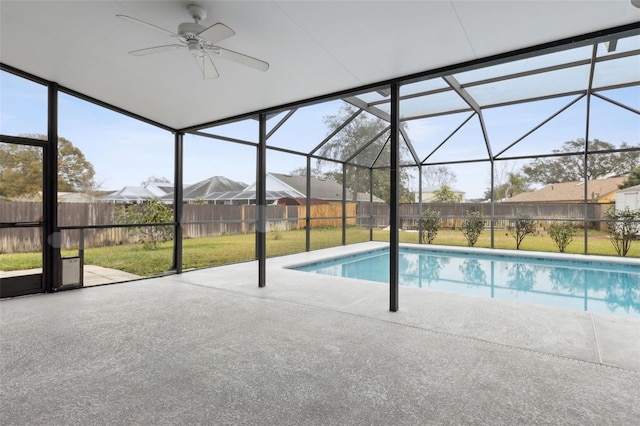 view of swimming pool featuring a patio, a lanai, ceiling fan, and a lawn