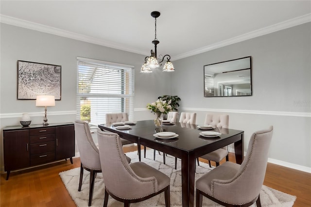 dining room featuring a notable chandelier, hardwood / wood-style flooring, and ornamental molding