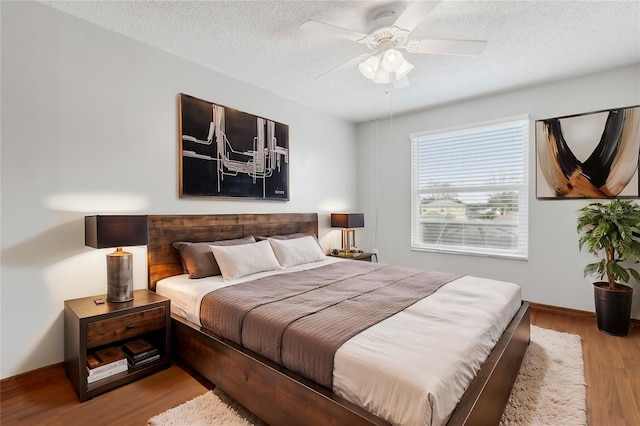 bedroom featuring ceiling fan, a textured ceiling, and light wood-type flooring