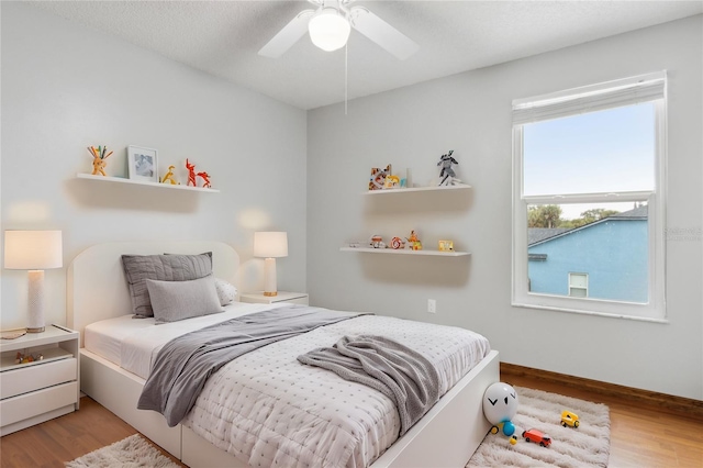 bedroom with ceiling fan and light wood-type flooring