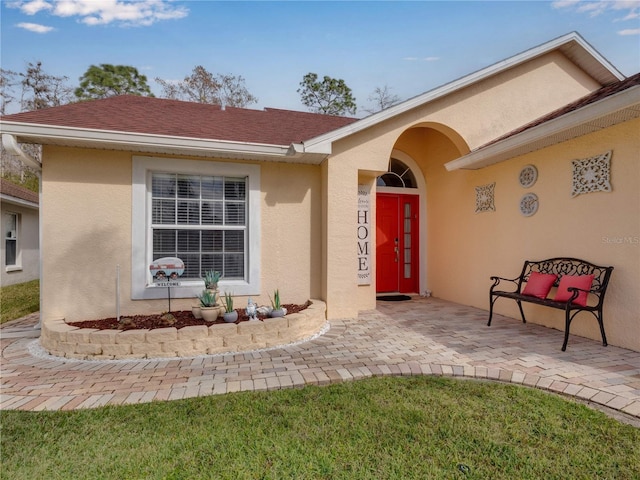 property entrance featuring a lawn