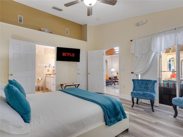 bedroom featuring ceiling fan, light hardwood / wood-style flooring, and ensuite bathroom