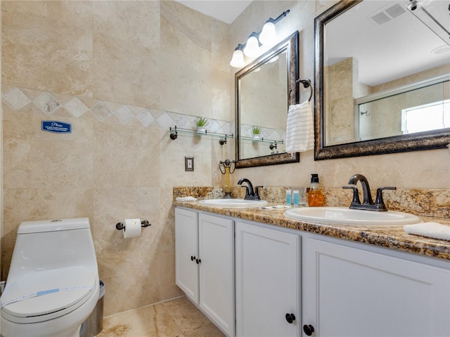 bathroom with toilet, tile patterned floors, vanity, and tile walls