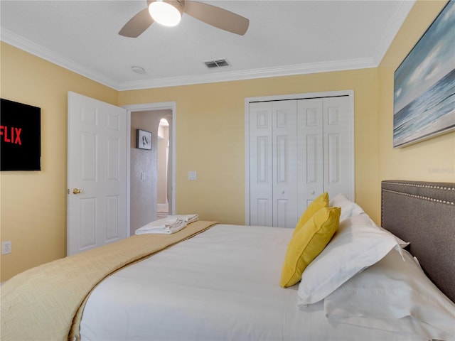 bedroom featuring ceiling fan, ornamental molding, and a closet