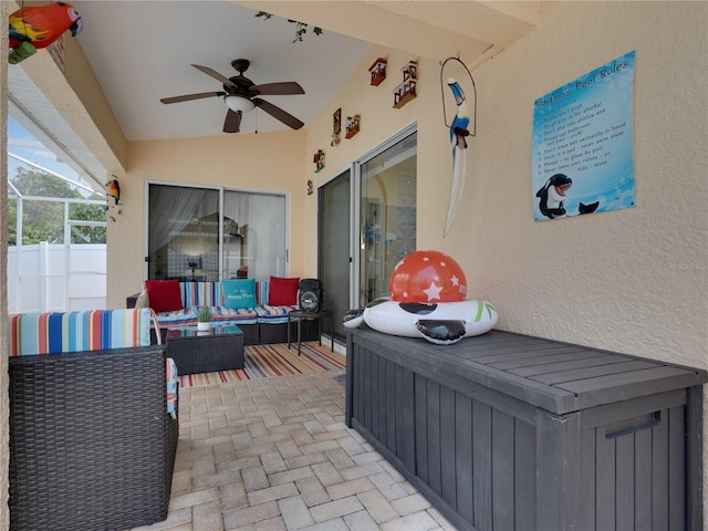 view of patio / terrace with ceiling fan, an outdoor hangout area, and glass enclosure