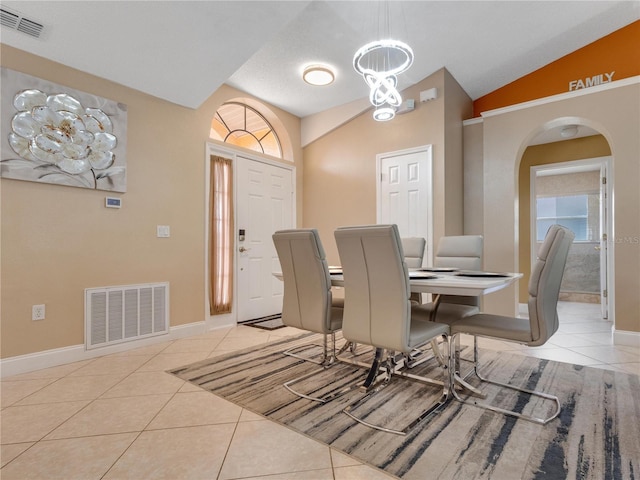 tiled dining area featuring lofted ceiling and a healthy amount of sunlight