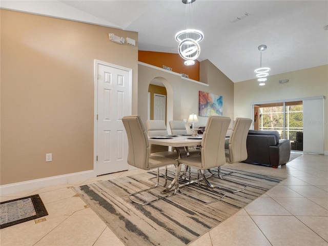 dining space featuring lofted ceiling, a chandelier, and light tile patterned floors