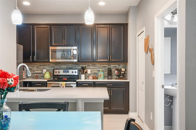 kitchen featuring decorative light fixtures, tasteful backsplash, dark brown cabinets, and appliances with stainless steel finishes