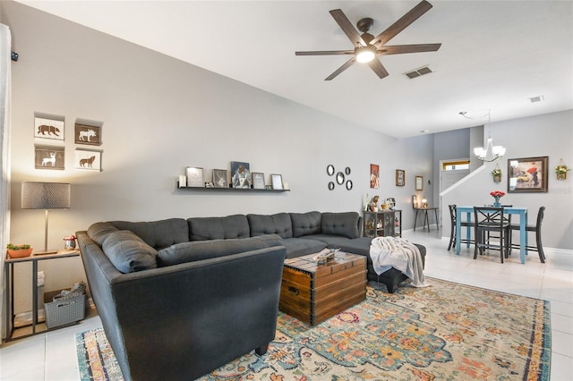 living room with ceiling fan with notable chandelier and tile patterned flooring