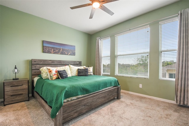 carpeted bedroom featuring ceiling fan and multiple windows