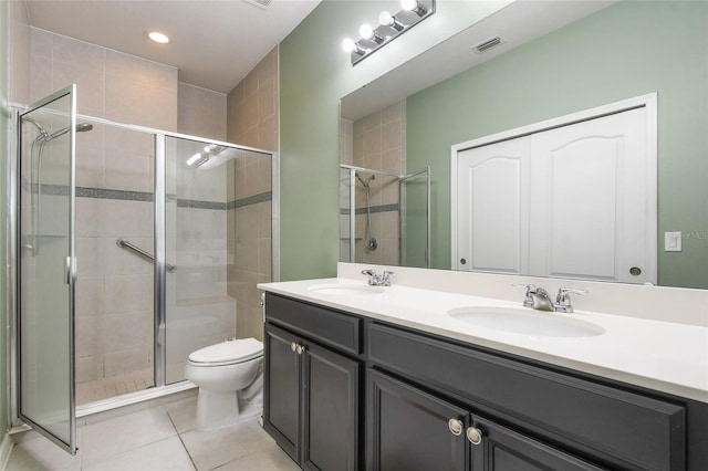 bathroom with tile patterned flooring, toilet, vanity, and a shower with shower door