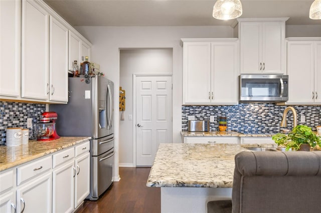 1416 Cabot Dr, Clermont, FL 34711 - kitchen with white cabinets, backsplash, stainless steel appliances, and dark wood-type flooring