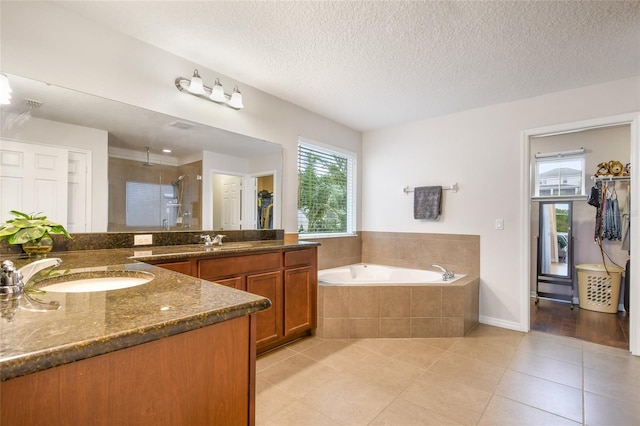 1416 Cabot Dr, Clermont, FL 34711 - full bath with a garden tub, tile patterned flooring, vanity, a stall shower, and a textured ceiling