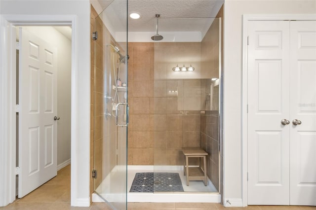1416 Cabot Dr, Clermont, FL 34711 - bathroom featuring a textured ceiling, tile patterned flooring, a stall shower, and baseboards